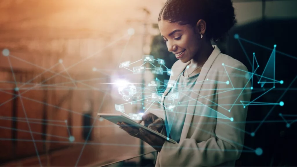 Technologie numérique et connectivité en entreprise - iterates Femme souriante utilisant une tablette avec des interfaces numériques en réalité augmentée.