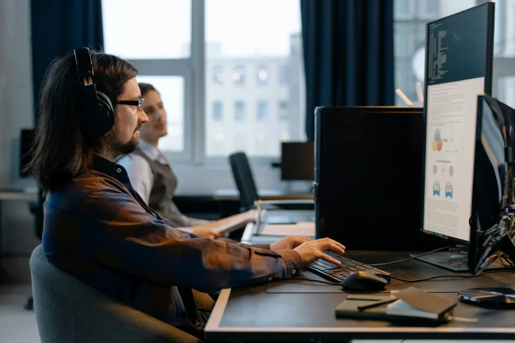 Développement de site web pour startups et PME - iterates Développeur web travaillant sur ordinateur dans un bureau moderne.