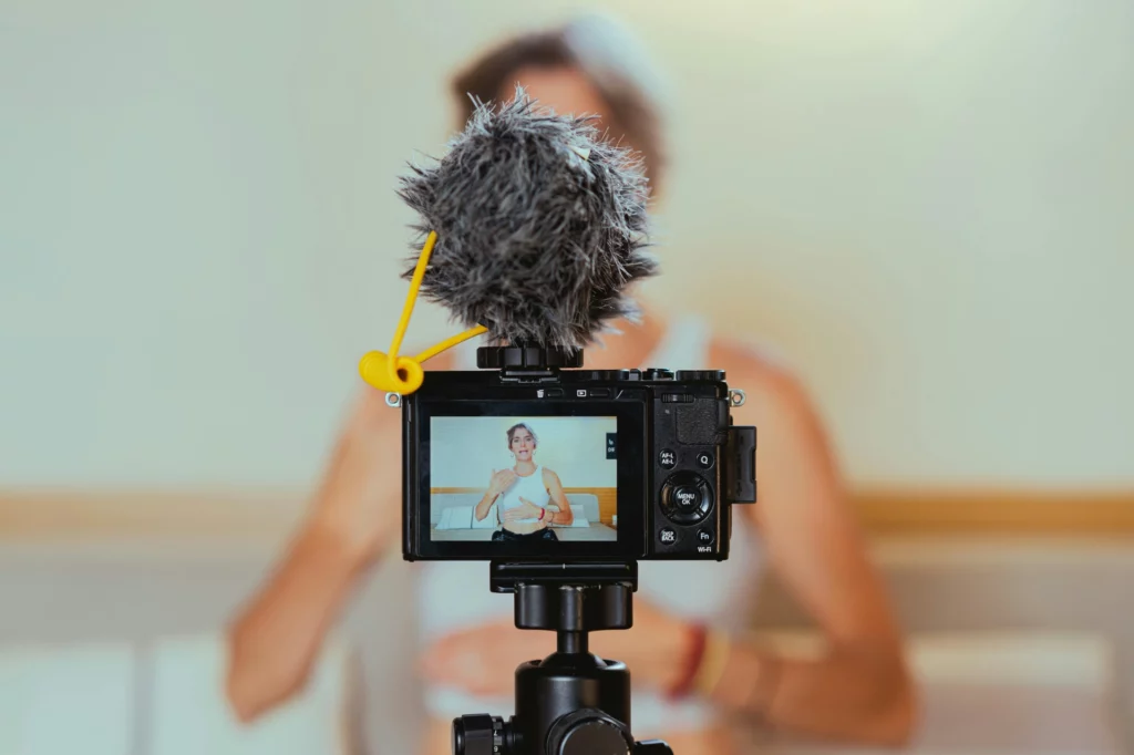 Création de contenu vidéo avec caméra et micro professionnel - iterates Caméra équipée d’un micro enregistrant une personne qui parle face à l’objectif.