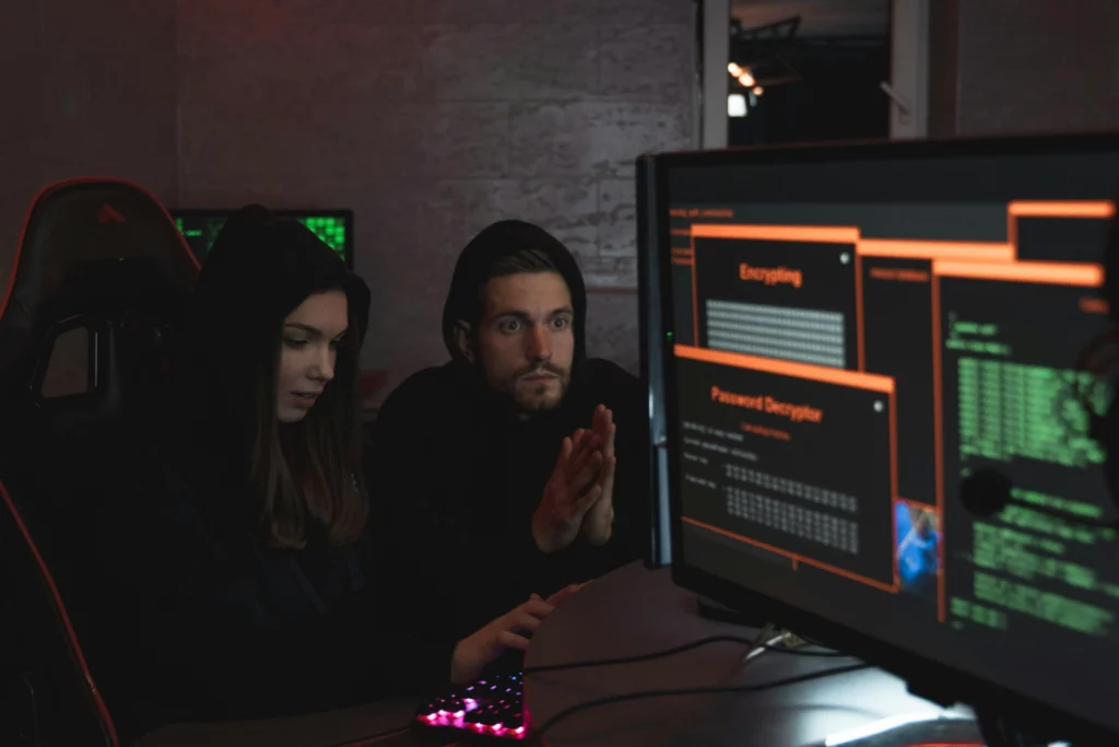 Hackers procédant au décryptage d’un mot de passe - iterates Deux hackers en sweat à capuche travaillant sur un ordinateur avec des écrans affichant un décryptage de mot de passe.