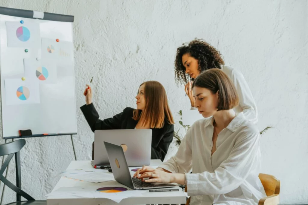 Trois femmes travaillant sur des graphiques lors d’une réunion de projet.