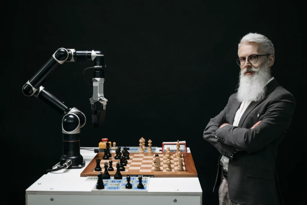 Un homme en costume observant un robot jouant aux échecs.