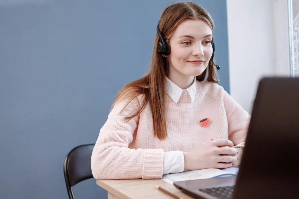 Conseillère en ligne en pleine réunion virtuelle - iterates Femme avec un casque micro participant à une visioconférence.