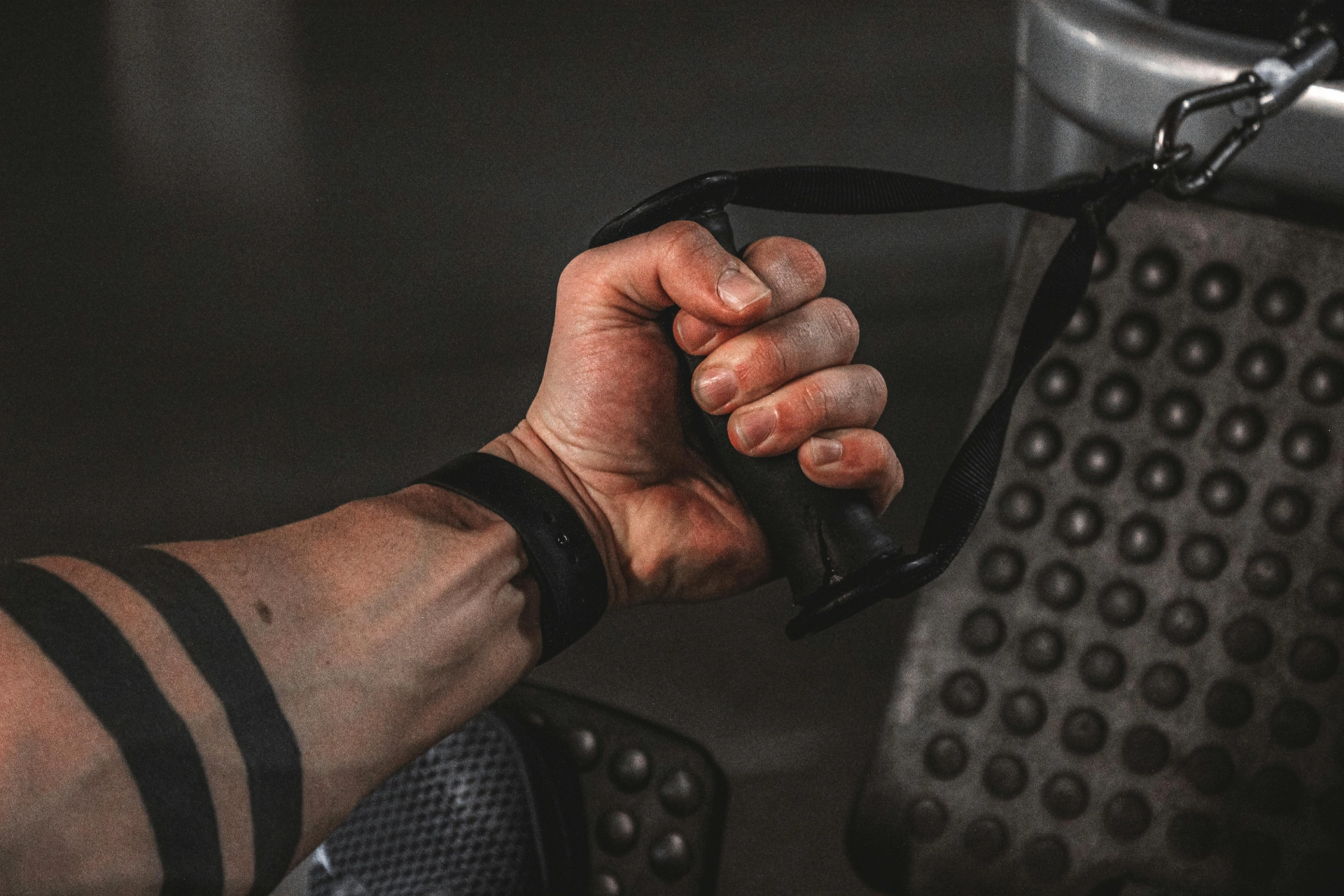 - iterates Hand holding a handle connected to a fitness machine.
