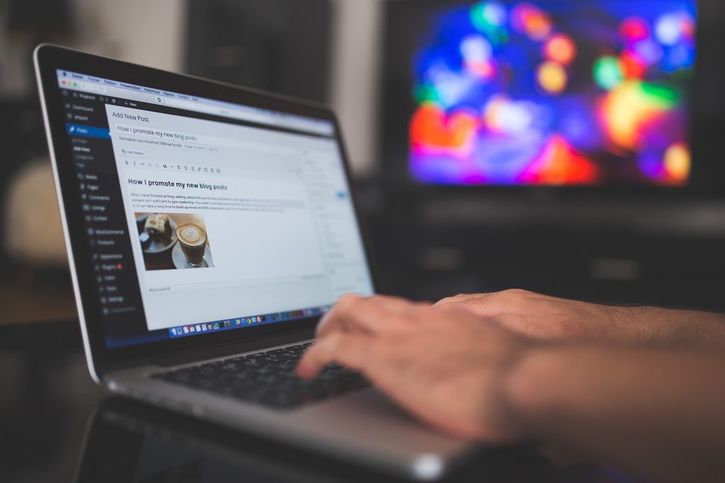 Laptop screen shows WordPress editor with a draft post and a coffee photo embedded in the post.